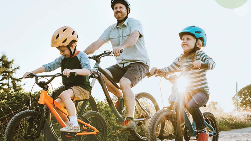 Father and children riding bicycles
